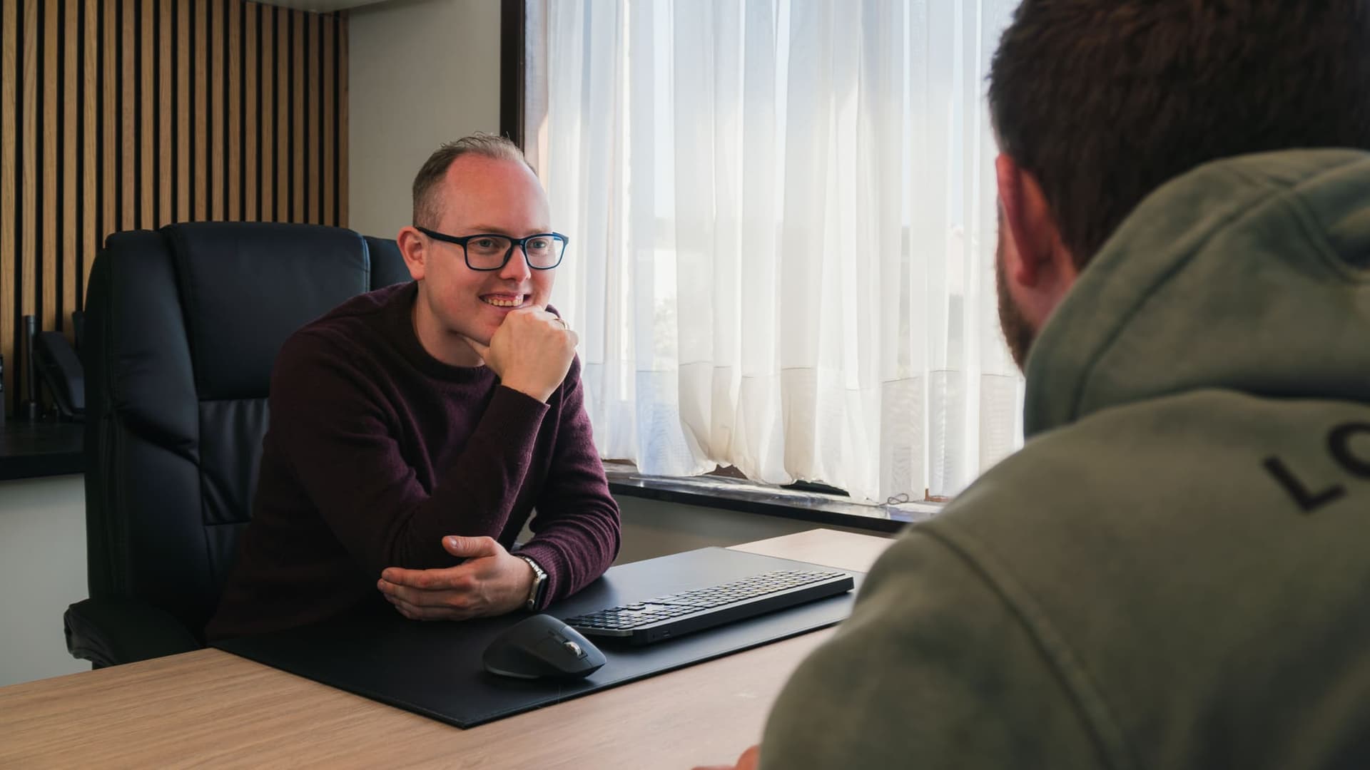 Davy Stevens in gesprek met een medewerker aan zijn bureau